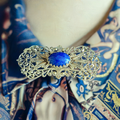 Filigrane Brosche mit blauem Stein – Reich verzierter Modeschmuck
