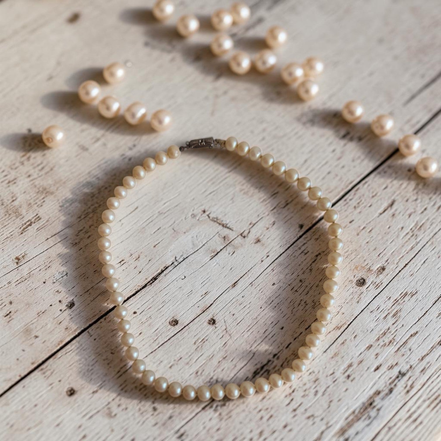 Klassiek parelcollier met onechte parels en zilveren sluiting van 835 zilver, 42 cm lang.