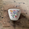 Handgeschilderd aardewerken schaaltje van Poole Pottery, model 41, met een BN-bloemendecor op een eierschaalwitte ondergrond.