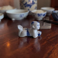 Chinees blauw-wit porseleinen miniatuurbeeldje van een kruipende Karako jongen, hoogte ca. 4 cm, eetstokjeshouder of decoratief object.