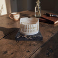 Miniatuurreplica van het Colosseum in Rome op een zwarte marmeren sokkel, hoogte 5 cm.