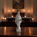 Ivoorkleurig albast beeldje van Onze-Lieve-Vrouw van Medjugorje in staande houding met gedrapeerd gewaad en sluier, hoogte 9,5 cm.