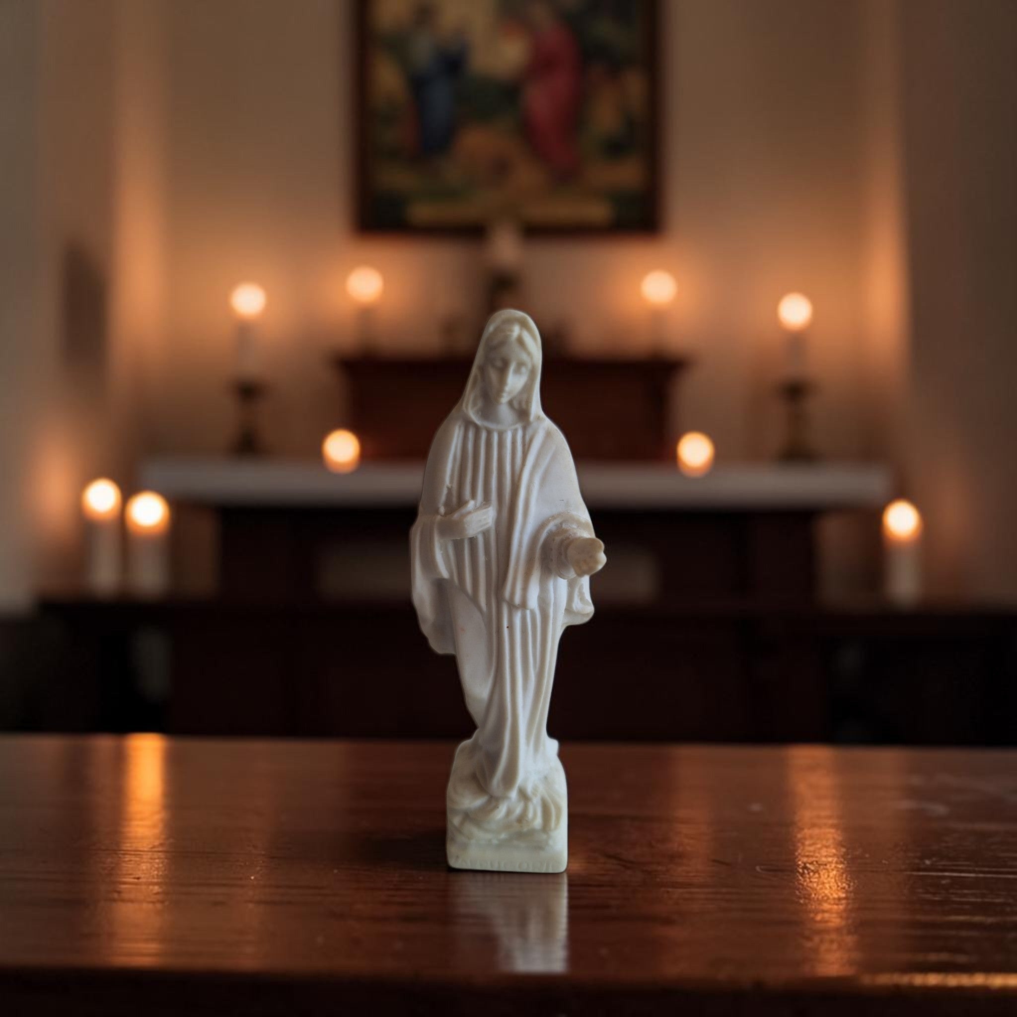 Ivoorkleurig albast beeldje van Onze-Lieve-Vrouw van Medjugorje in staande houding met gedrapeerd gewaad en sluier, hoogte 9,5 cm.