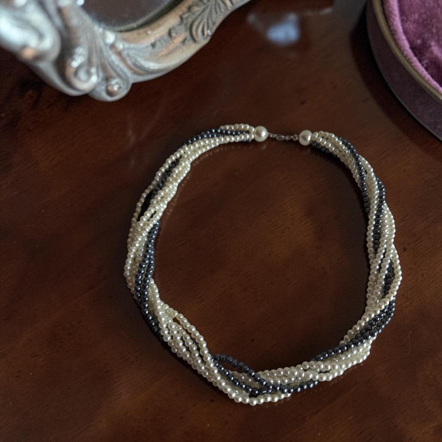 Vintage meerrijig gedraaid parelcollier in wit en zwart met imitatieparels, lengte 48 cm.
