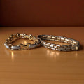 Set van twee vintage dames schakelarmbanden: goudkleurige baksteenschakel (18,5 cm) en bicolor ovale schakel met geelgouden en witgouden schakels (18 cm), beide in goede staat.
