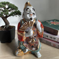 Japans Kutani porseleinen beeldje van zittende man met waaier, rijke moriage emaille en vergulde accenten, gerestaureerd, Japan late 19e eeuw, H16 cm