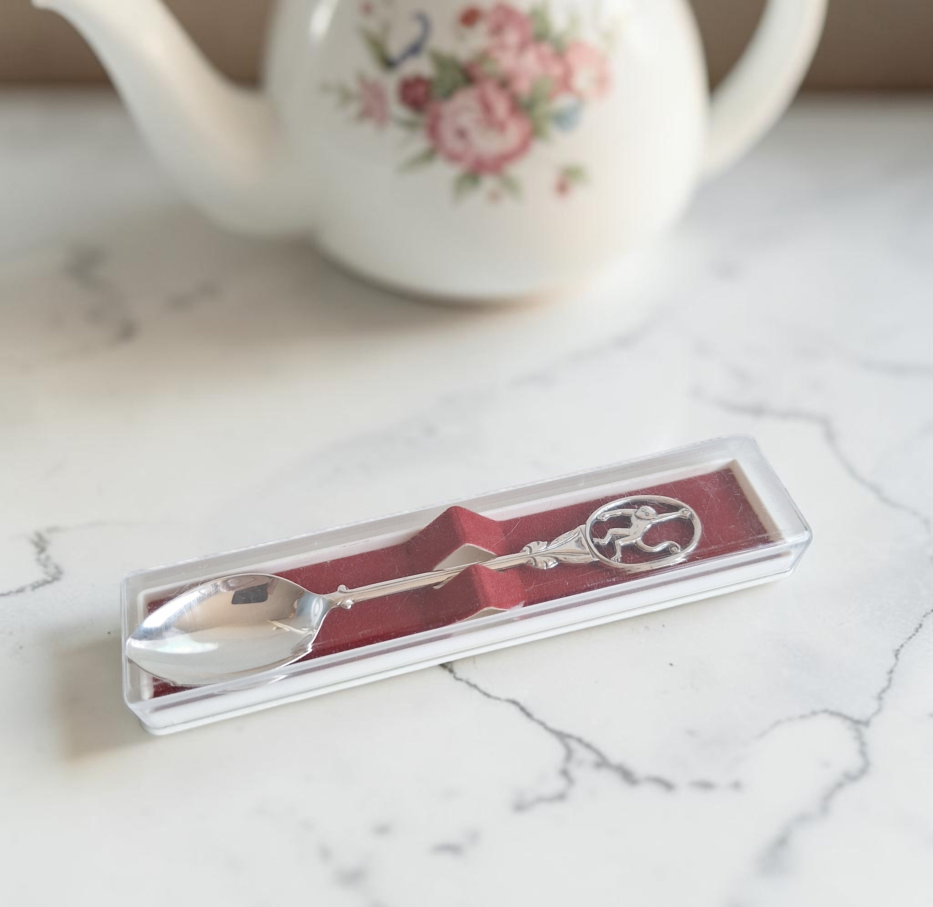 Verzilverd theelepeltje van Stichting AAP in houder, 12 cm, vintage tafelzilver souvenir.