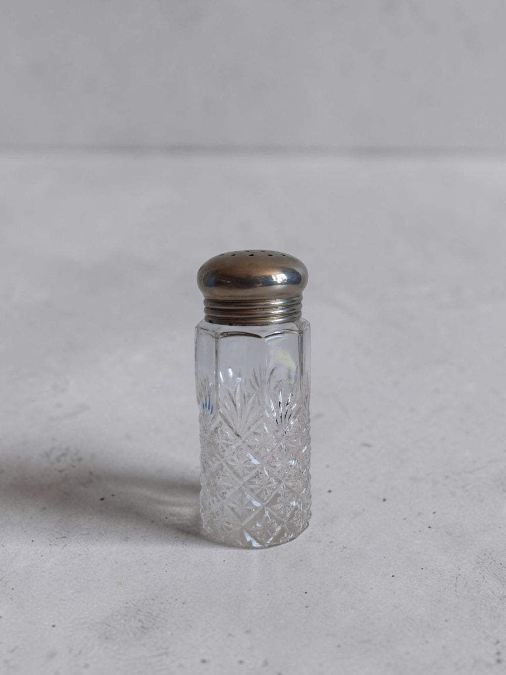 Antieke Art Deco zoutstrooier van helder geslepen glas met diamantpatroon en verzilverde dop, hoogte 12,5 cm, circa jaren '20–'40.