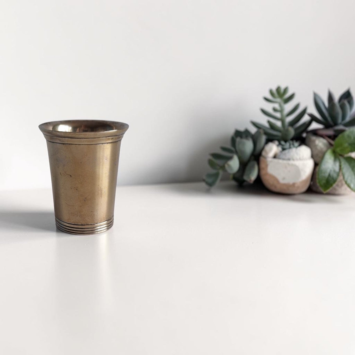 Vintage messing drinkbeker in Mint Julep stijl met taps toelopende vorm, geprofileerde ringen aan de onderkant en warm goudachtig patina, hoogte 7,5 cm.