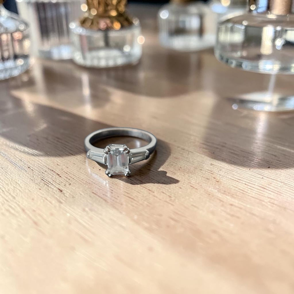 Vintage verzilverd koperen damesring met smaragdgeslepen centrale strass-steen en baguette zijstenen, binnenmaat 17,2 mm
