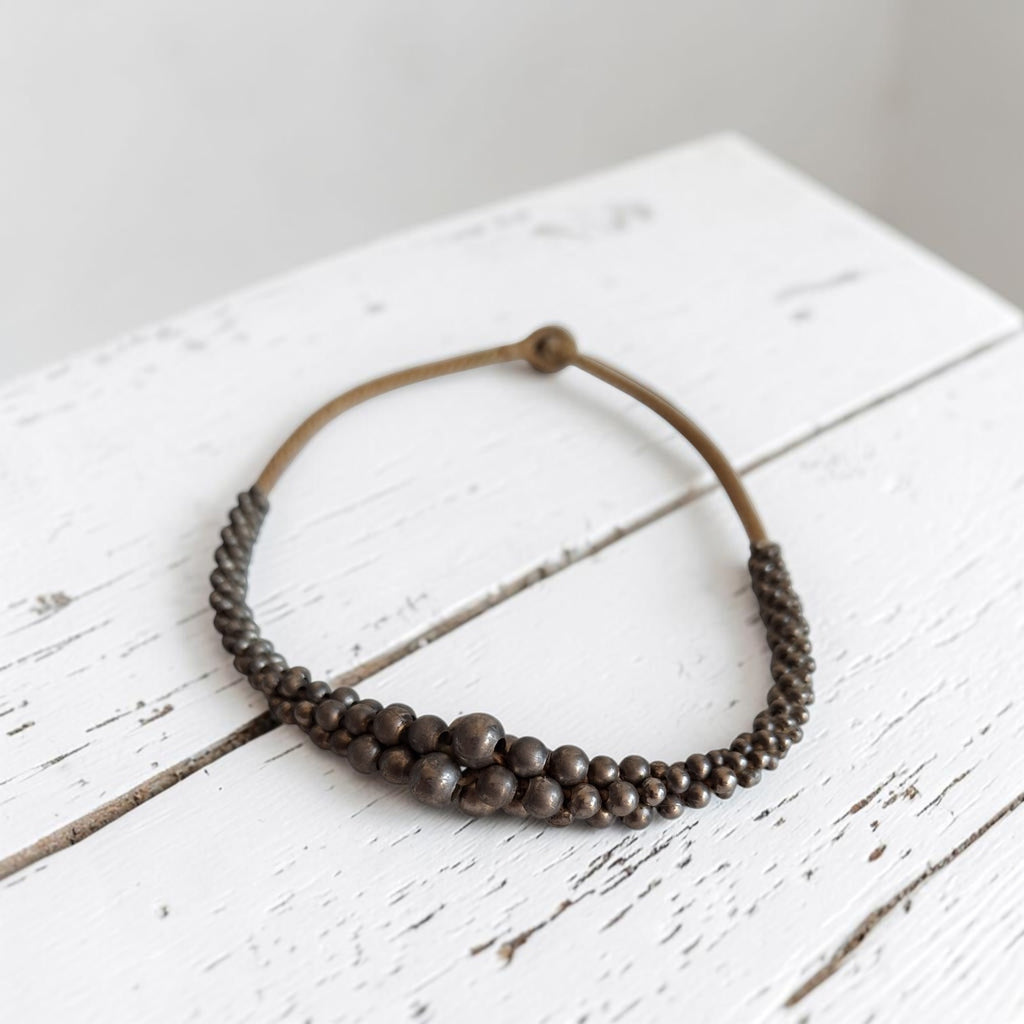 Vintage bronskleurig houten kralencollier met bolletjes in verschillende maten op touw geregen, lengte 44 cm.
