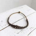Vintage bronskleurig houten kralencollier met bolletjes in verschillende maten op touw geregen, lengte 44 cm.
