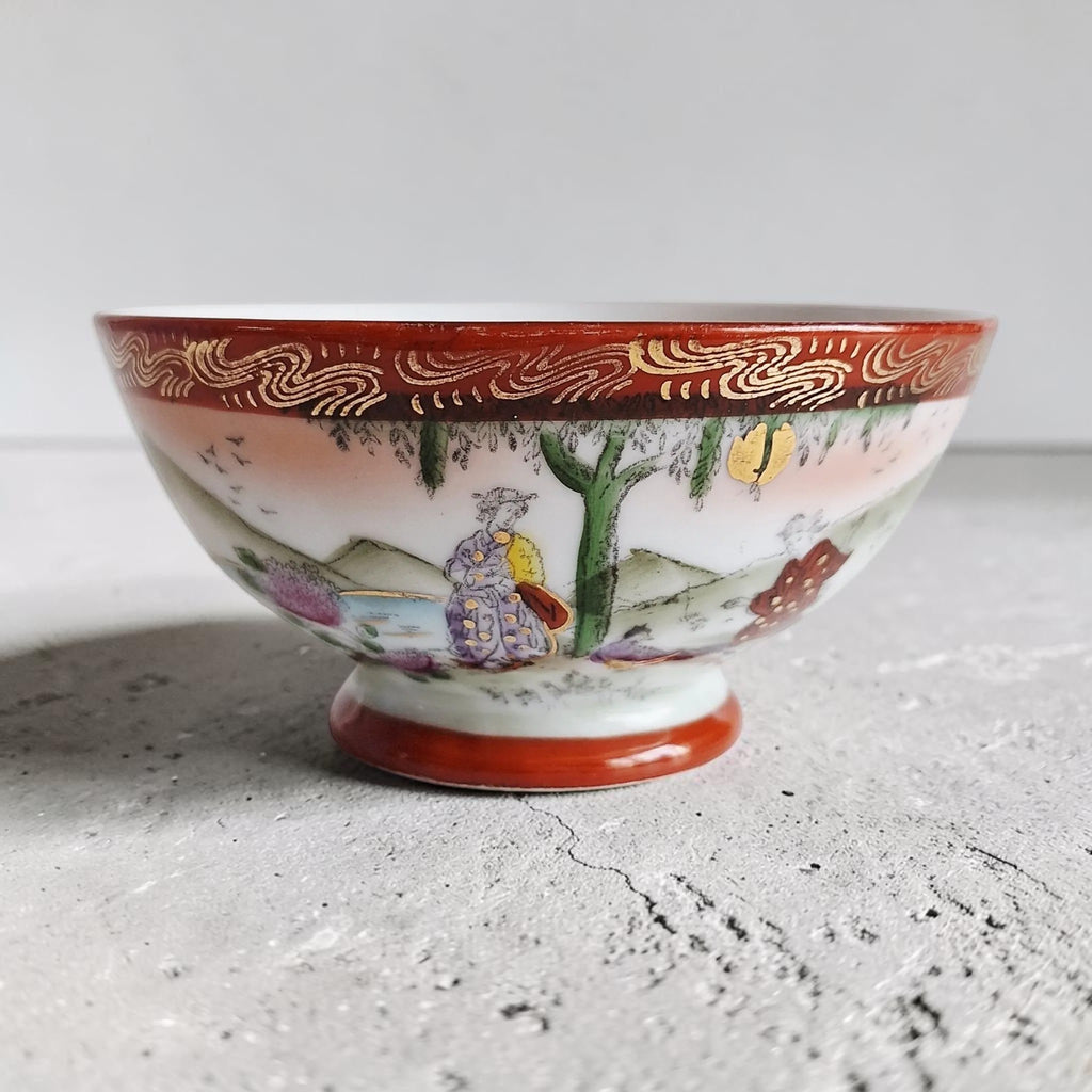 Handgeschilderde porseleinen kom van Striegau Silesia met Osaka-decor, landschapstafereel en goudkleurige randdetails uit de vroege 20e eeuw.