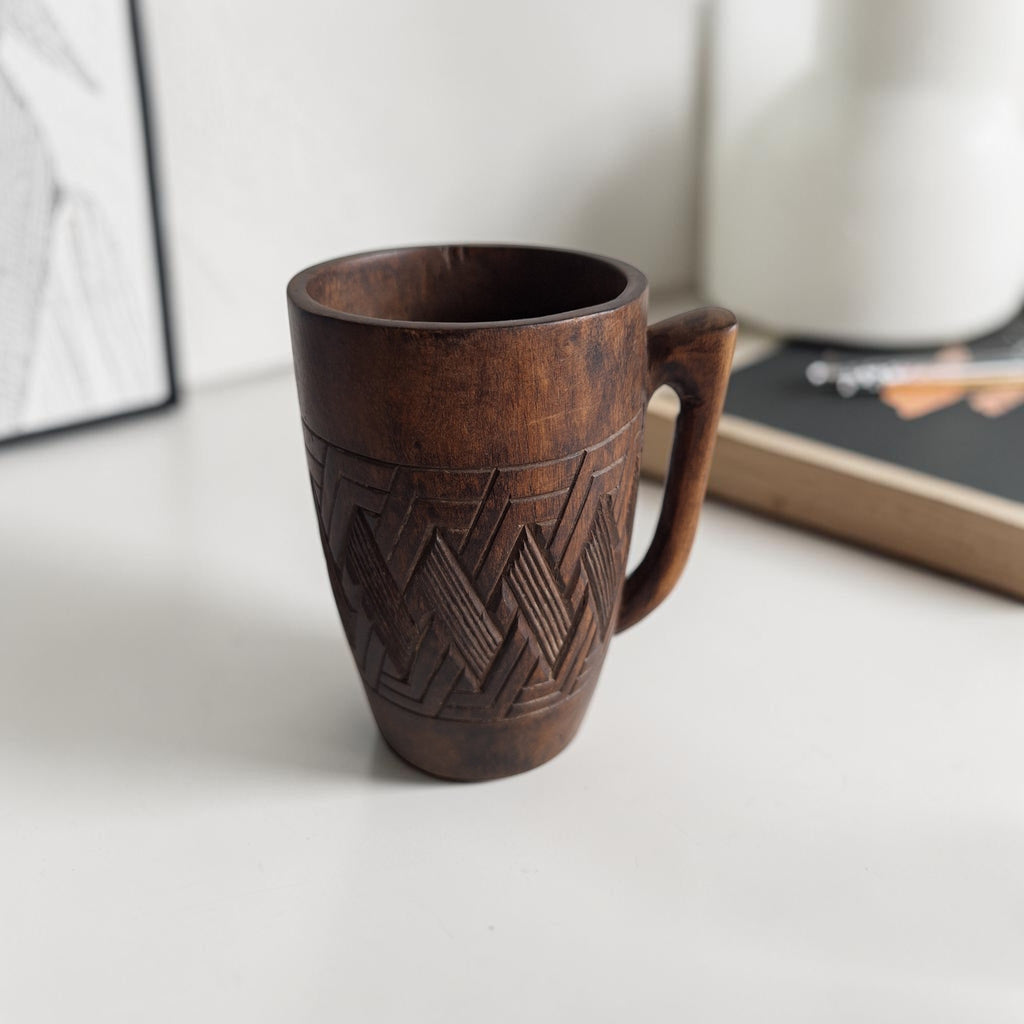 Handgesneden Kuba palmwijnkop uit Congo met een robuust oor, donkere patina en geometrische vlechtpatronen rondom.
