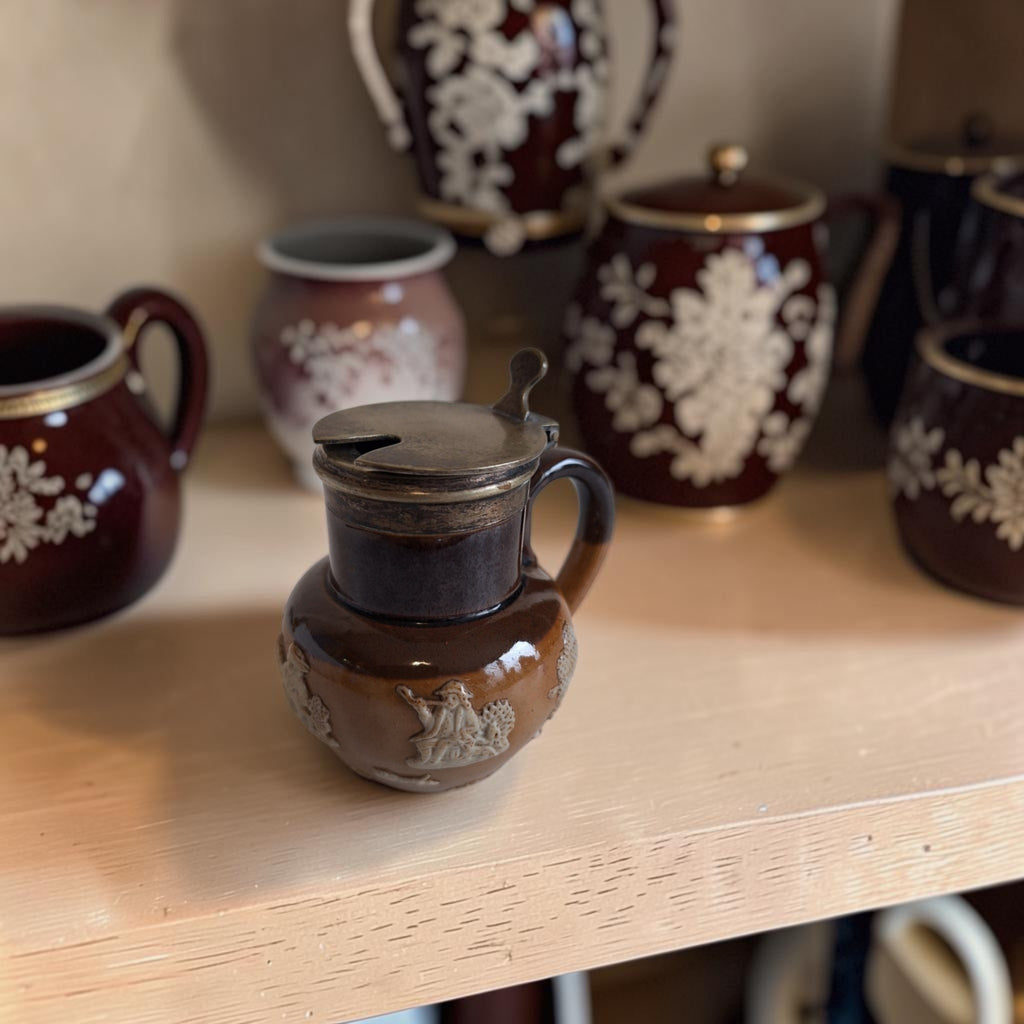 Doulton Lambeth mosterdpotje van tweekleurig steengoed met crèmekleurige reliëfscènes en een verzilverd EPNS-deksel.