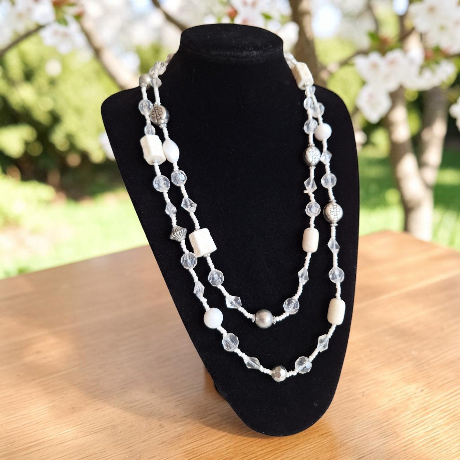 Vintage dubbelstrengige lange kralenketting met afwisseling van witte en transparante kralen, lengte 140 cm.
