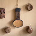 Handgemaakte houten lepel met brede ronde kom en donker handvat met ingegraveerde geometrische patronen en een ophangat.
