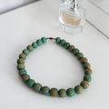Vintage chunky collier van grote ronde houten kralen met groen-bruin gemêleerde afwerking, lengte 44 cm.
