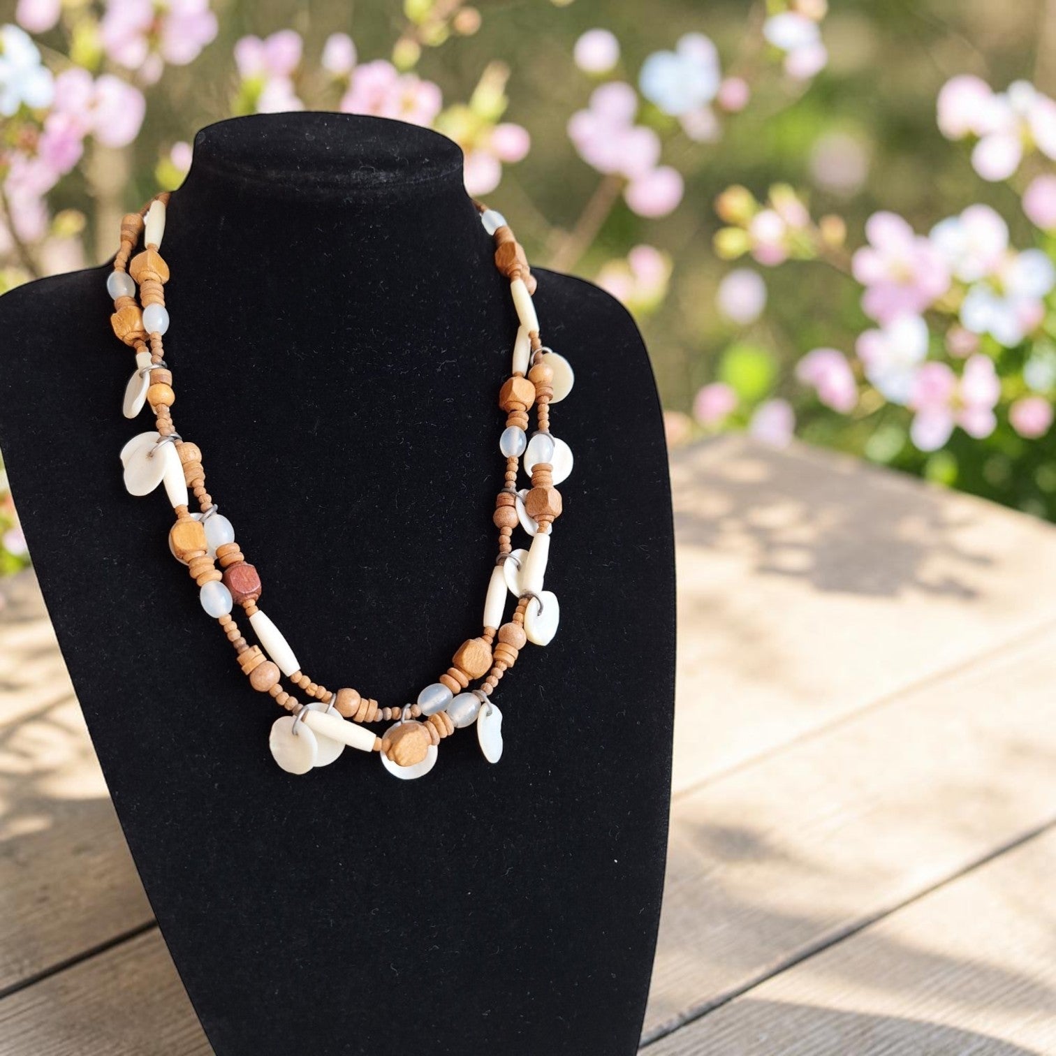 Vintage meerlaagse boho-halsketting met bruine houten kralen en witte schelpschijven, lengte 55 cm.
