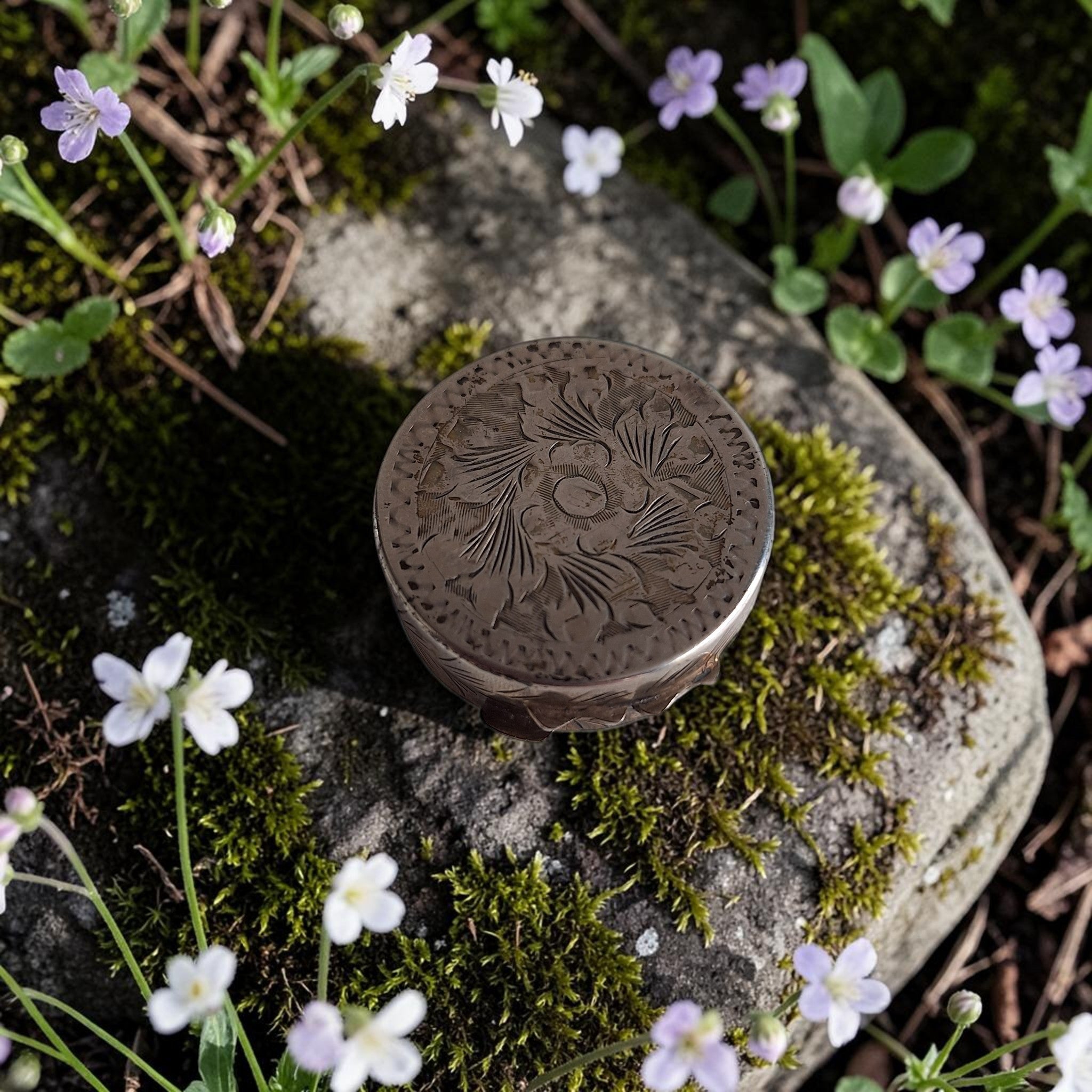 Verzilverd rond pillendoosje met bloemenreliëf en krulgraveringen op schanierdeksel, mogelijk 800 of 925 sterling zilver, H1,2 Ø3,1 cm, 9 gram