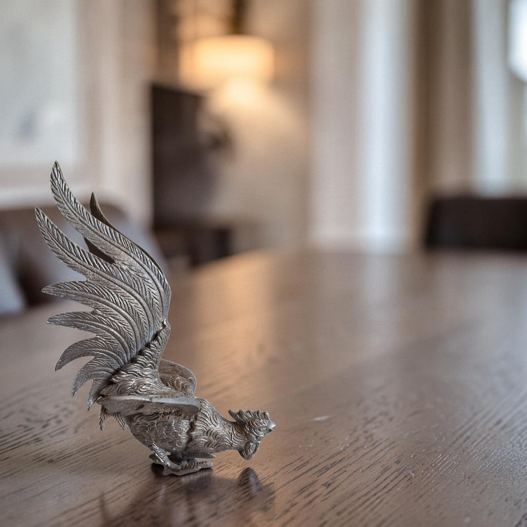 Groot zilverkleurig gegoten metalen kemphaan beeldje in aanvalshouding met gespreide vleugels, hoogte ca. 18,5 cm.