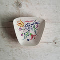 Poole Pottery schaaltje model 41 met handgeschilderd BN-bloemendecor op een eierschaalwitte ondergrond.