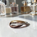 Vintage driekleurige trinity-stijl damesring met ineengestrengelde banden in goud, rosé en zilver met strass, binnenmaat 17,6 mm
