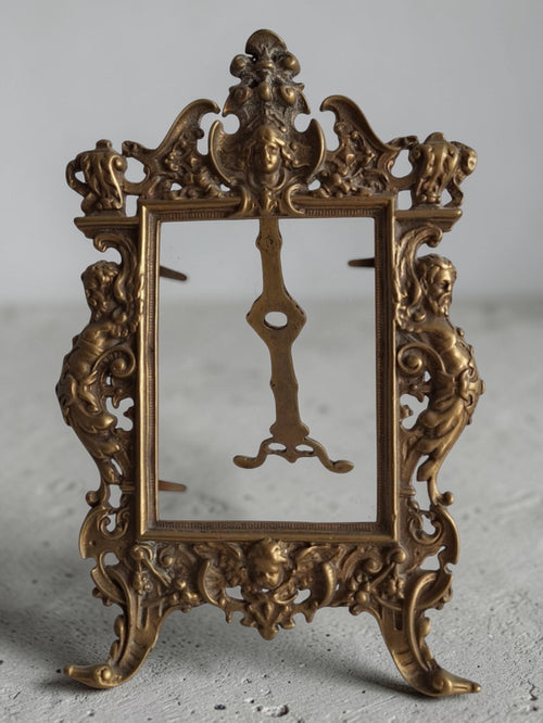 Antieke messing fotolijst in Rococo en Art Nouveau stijl met bladmotieven en menselijke figuren, hoogte 8 cm, breedte 18,4 cm. | 2nd Hand Bargain