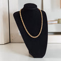 Vintage goudkleurige gedraaide touwketting met blauwe kraal en grove sluiting, lengte 59 cm.
