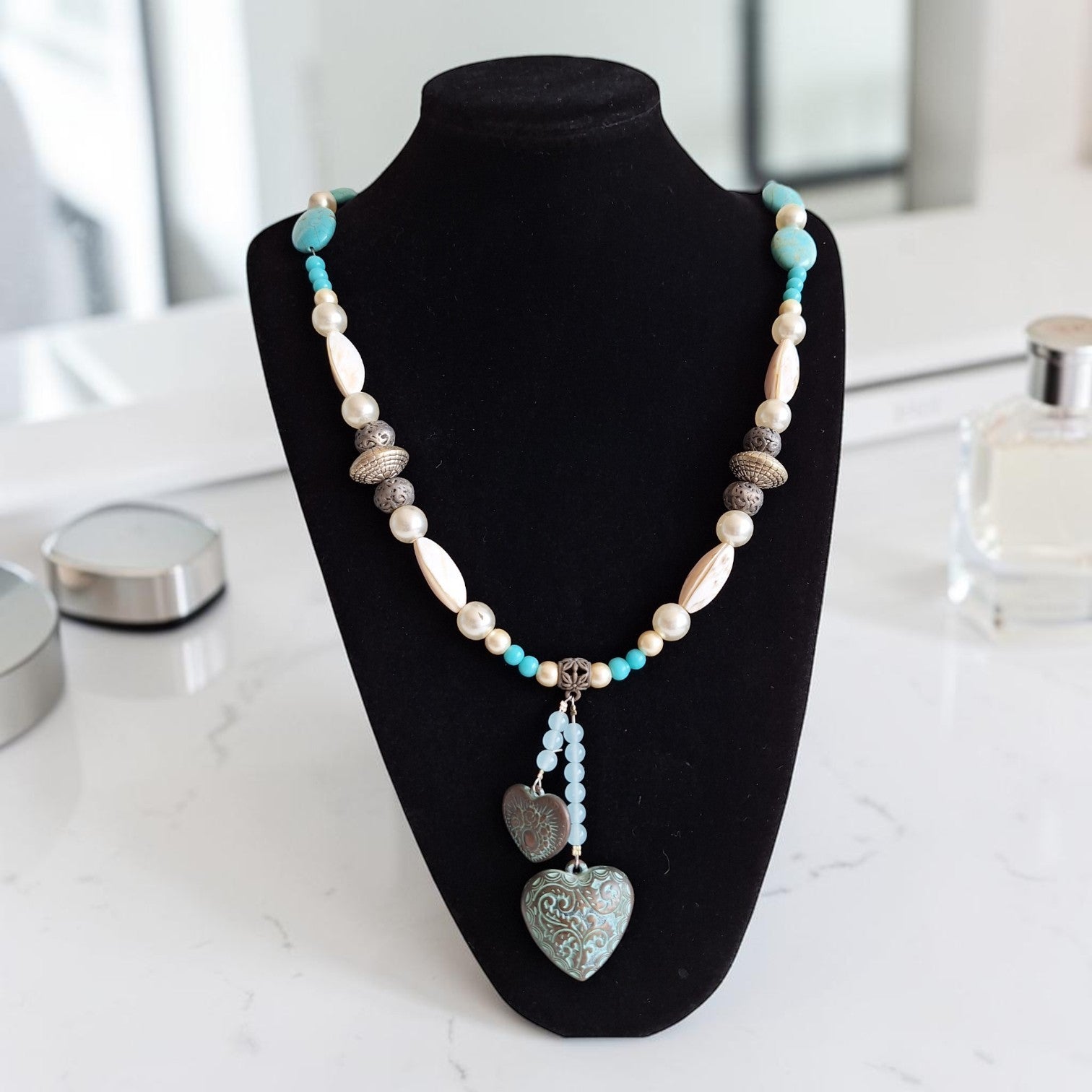 Vintage turquoise, zilver en wit kralenketting met twee hartvormige hangers en bijzondere vintage sluiting, lengte 77 cm.