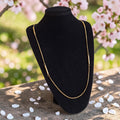 Vintage goudkleurige lange schakelketting met subtiele cilindrische accenten, lengte 96 cm.
