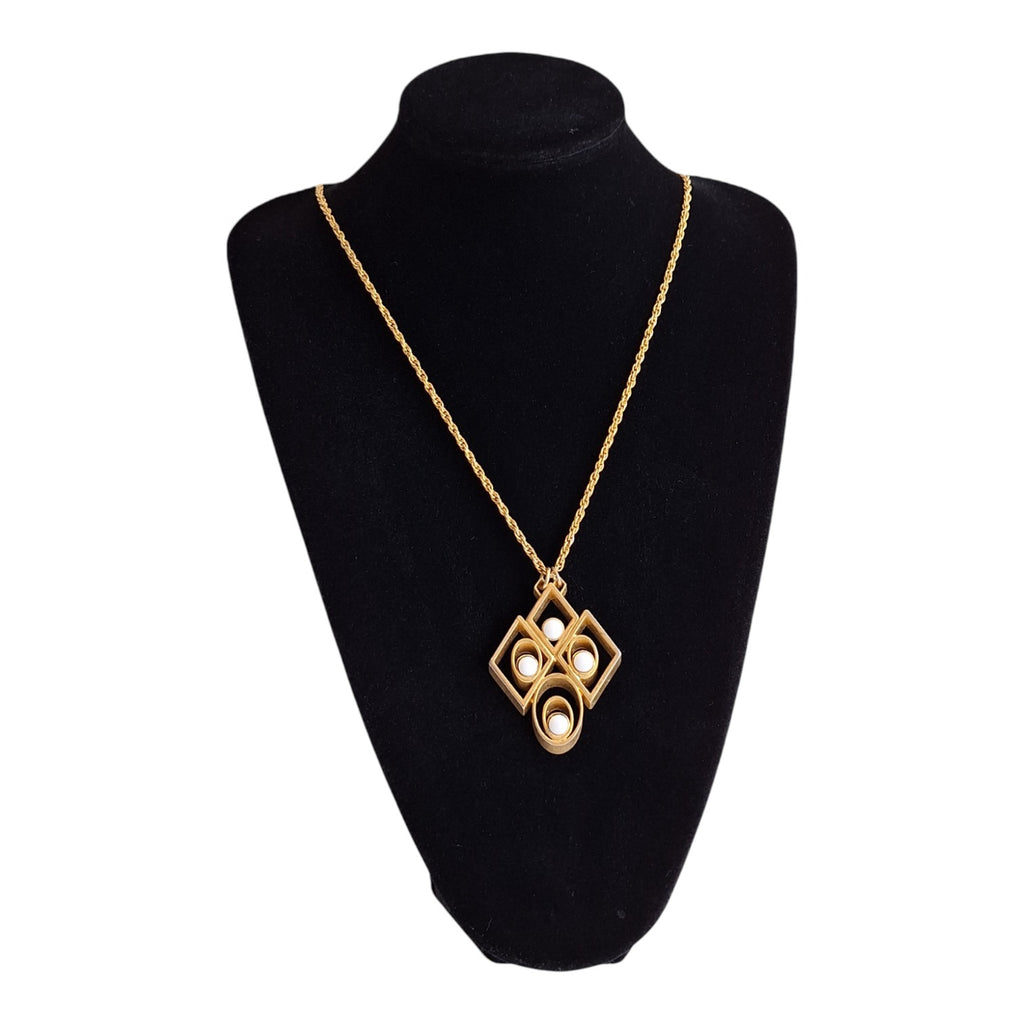 gold-coloured necklace with an abstract pendant