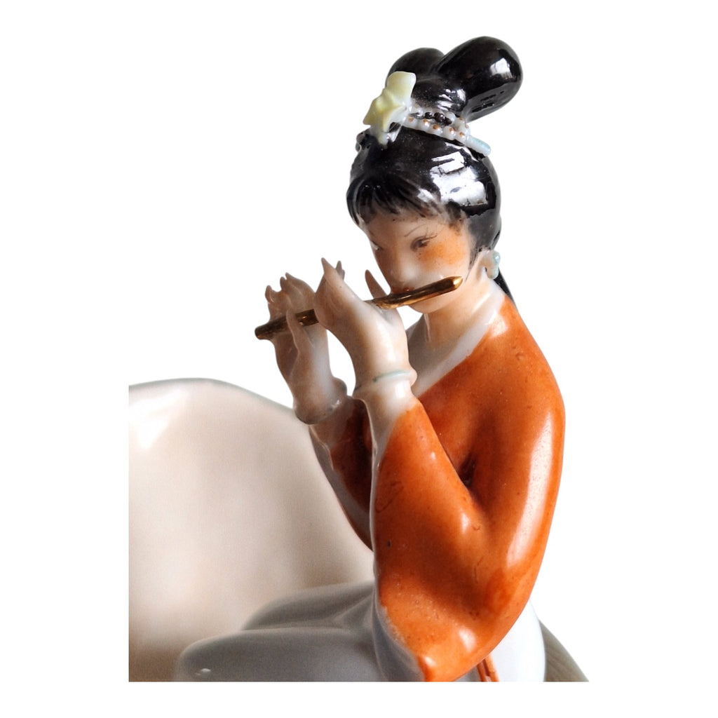 Porzellanfigur Geisha auf Muschel mit Flöte – Japanisch